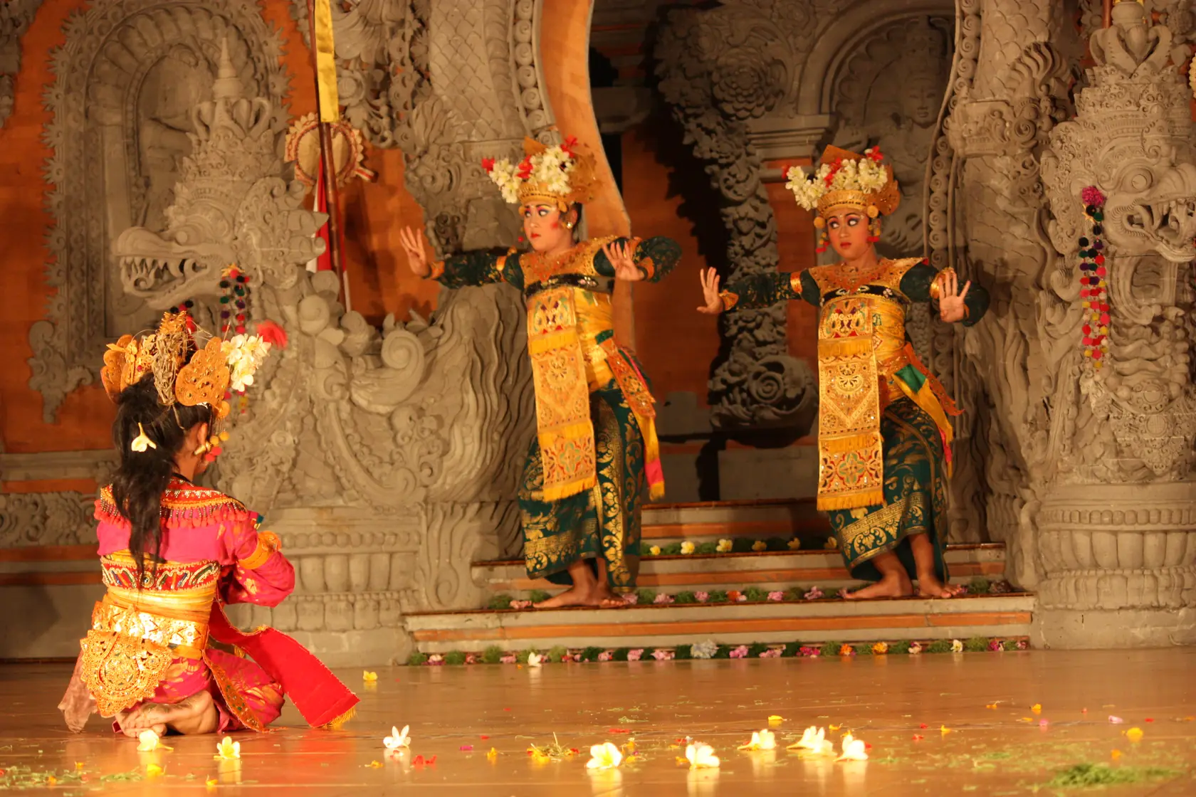 A Balinese Legong dancer in an elaborate gold costume and headdress mid-performance